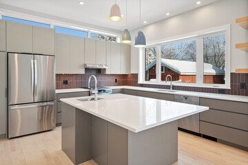 A modern kitchen with a white island and stainless steel appliances