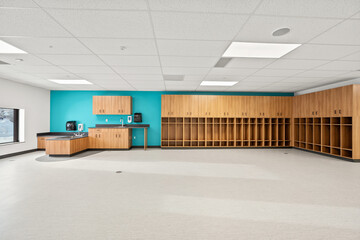 A large empty room with a blue wall and wooden cabinets