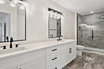 A bathroom with a white counter and a black sink