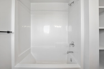 A white bathroom with a white bathtub and a white shower