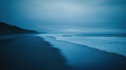 Obraz premium Serene twilight beach, waves rolling in, coastal cliffs, moody atmosphere; travel, nature backdrop