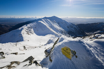 Ziarska dolina and Baranec, view from Placlive, Zapadne Tatry, Western Tatras, Slovakia. Winter mountain landscape with snow. Signboard on the rock. Top, peak, summit and valley. Shallow focus. © M-SUR