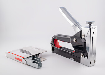 impact stapler and staples isolated on grey background, close-up