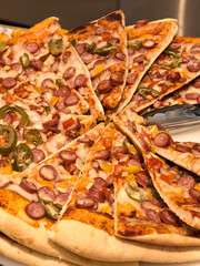 Slices of delicious pizza topped with colorful vegetables and sausages