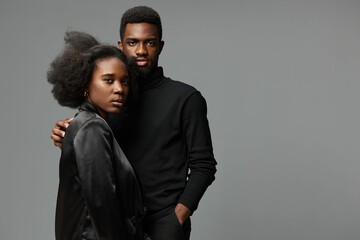 Stylish young African American couple with natural hairstyles posing confidently in modern attire...