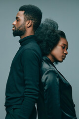 Obraz premium Elegant portrait of a couple with Afro hairstyle, showcasing emotional depth and style, with a monochromatic gray background, ideal for concepts of love and unity