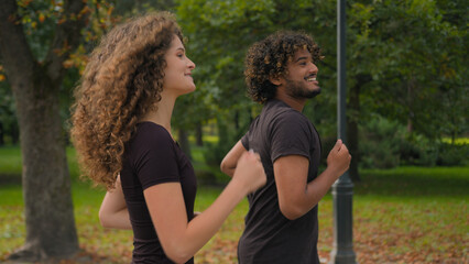 Indian man Caucasian woman multiracial couple friends girl guy happy sport people athletes running together in park outdoors morning run jog healthy workout jogging exercise active lifestyle in city