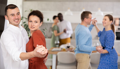 Fototapeta premium Friends party - men and women of different nationalities dancing slow dance