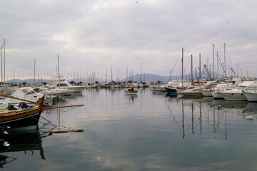 Fototapeta premium boats in the harbor, Pleasure boats in the port of Alghero. with the Capo Caccia promontory in the background Alghero, Sardinia, Italy.
