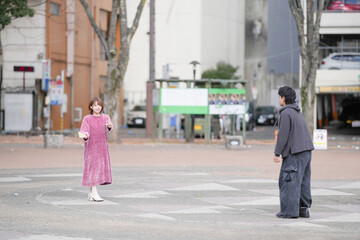 A Japanese man and woman in their 20s are playing hagoita, a traditional New Year's game, in a deserted park in Sakae, Naka Ward, Nagoya City, Aichi Prefecture.