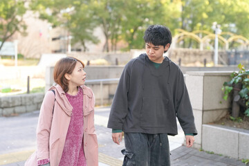 Fototapeta premium A Japanese man and woman in their 20s are walking on a public road in Sakae, Naka Ward, Nagoya City, Aichi Prefecture.