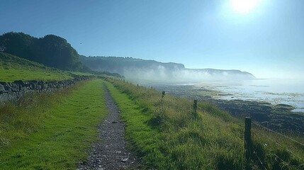 Serene coastal path with misty cliffs and lush greenery.