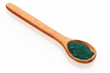 Organic green spirulina powder in a spoon - Nutritional supplement.