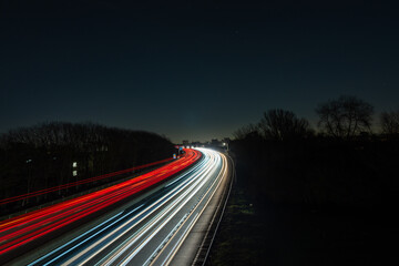 Long road with red lights streaking by