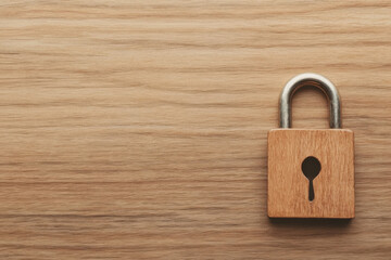 Fototapeta premium A wooden lock with a keyhole sits on a wooden surface
