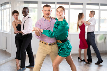 Fototapeta premium During rehearsal of reporting concert, man and woman participants of dance workshop perform figure waltz. Group training and rehearsal, preparation for competitions