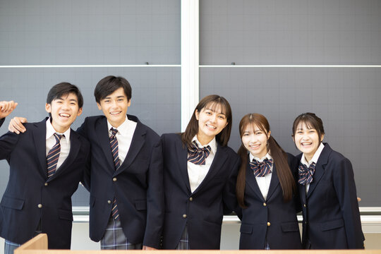 黒板の前で笑う学生たち