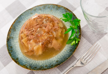 National Russian dish is a kholodets made from a jelly-like mass of chilled meat broth with pieces of meat and decorated ..with a sprig of fresh parsley