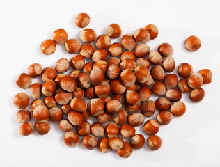 Top view of pile of unshelled filbert nuts on white surface. Healthy snack