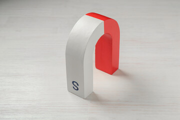 One horseshoe magnet on white wooden table