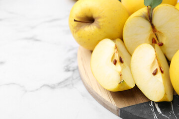 Ripe yellow apples on white marble table, closeup. Space for text