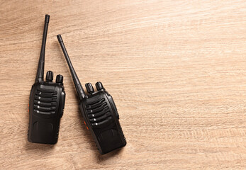 Walkie talkies on wooden table, top view. Space for text