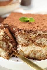 Delicious tiramisu with mint on plate, closeup