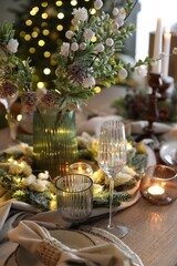 Christmas place setting with festive decor on wooden table in room