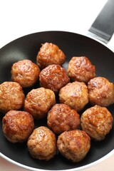 Tasty meatballs in frying pan on white table, closeup