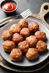 Tasty cooked meatballs served on grey table, closeup