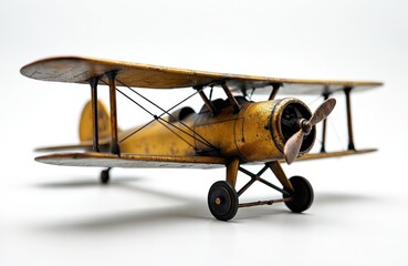 Vintage model biplane stands on white surface. Weathered gold finish gives plane antique look....