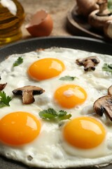 Tasty fried eggs with mushrooms and parsley served on table, closeup