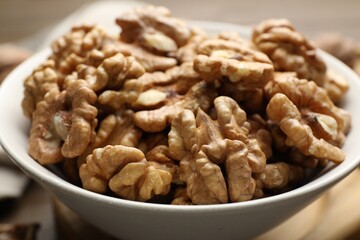 Peeled walnuts in bowl on table, closeup