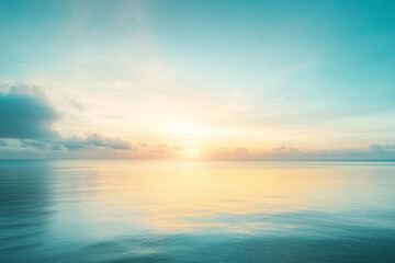 Obraz premium A serene sunrise over a calm ocean, featuring soft hues of blue and gold reflecting on the water's surface