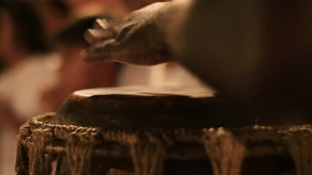 detail of a man playing the atabaque, a percussion instrument made of leather of African origin