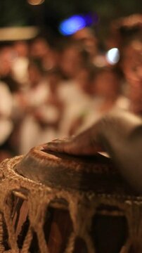 detail of a man playing the atabaque, a percussion instrument made of leather of African origin
