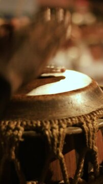 detail of hands playing a percussion instrument made of leather. Instrument of African origin