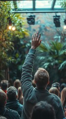 Fototapeta premium Man raising hand in a crowded indoor garden.