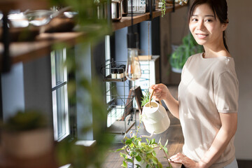 観葉植物に水やりをする女性
