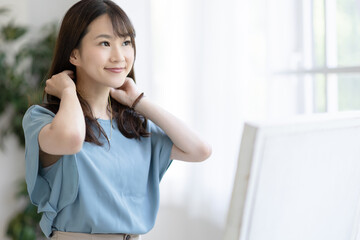 鏡の前で身支度する女性