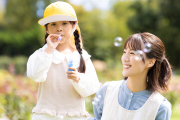 Obraz premium 公園で遊ぶ保育士と園児