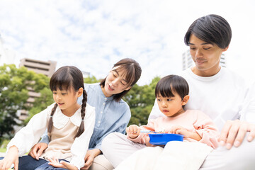 公園でお弁当を食べる保育士と園児