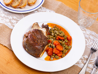 Appetizing baked pork cheek served with beans on plate