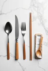 Flat Lay of Silverware and Wooden Chopsticks on Marble Surface