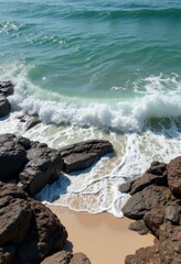 Turquoise Ocean Wave Crashing Against Sandy Beach Rocks