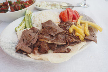 top view of lamb doner kebab, rice and chips on a plate