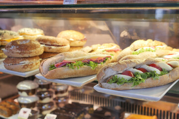 Freshly made sandwiches and pastries in a bakery display case