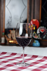 glass of red wine on glass table with backlight silhouette, romantic photo