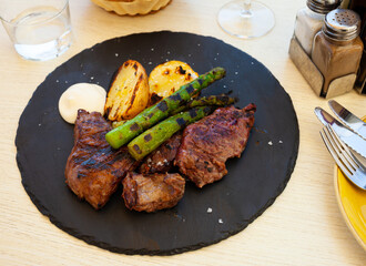 Grilled meat with arugula and potatoes closeup