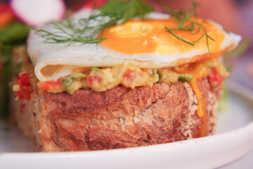 Delicious bread topped with a sunny-side-up egg and herbs